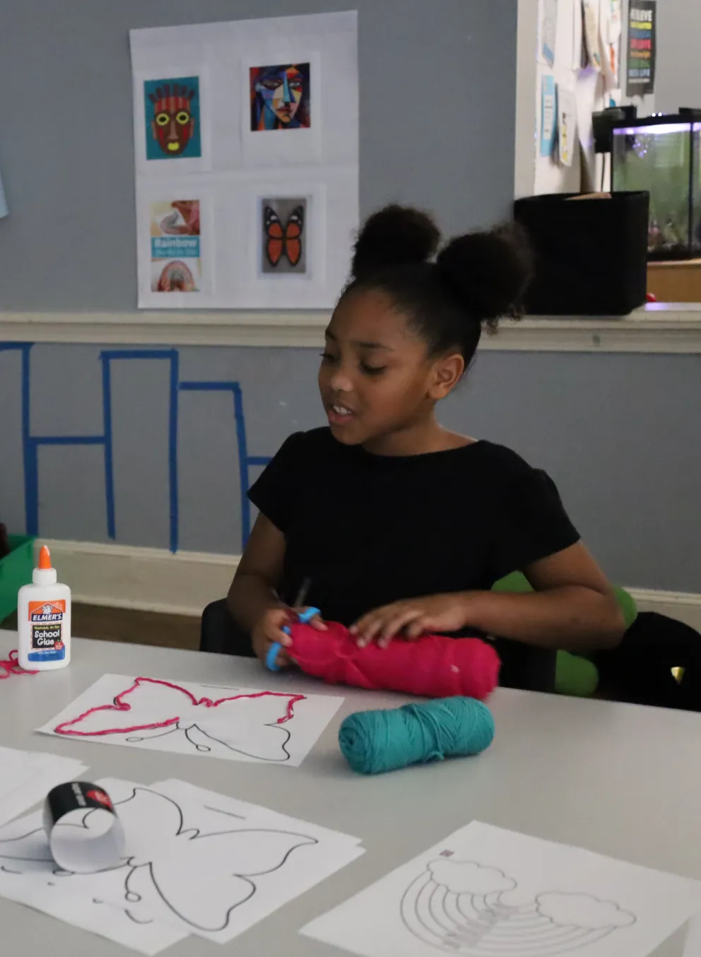 Female staff assisting a girl with her art project